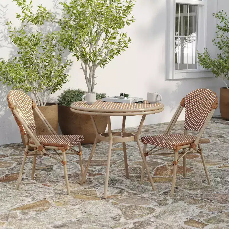 Table de style bistrot Celia de Merrick Lane avec plateau en verre trempé, rotin PE et cadre en métal finition bambou pour usage intérieur/extérieur.