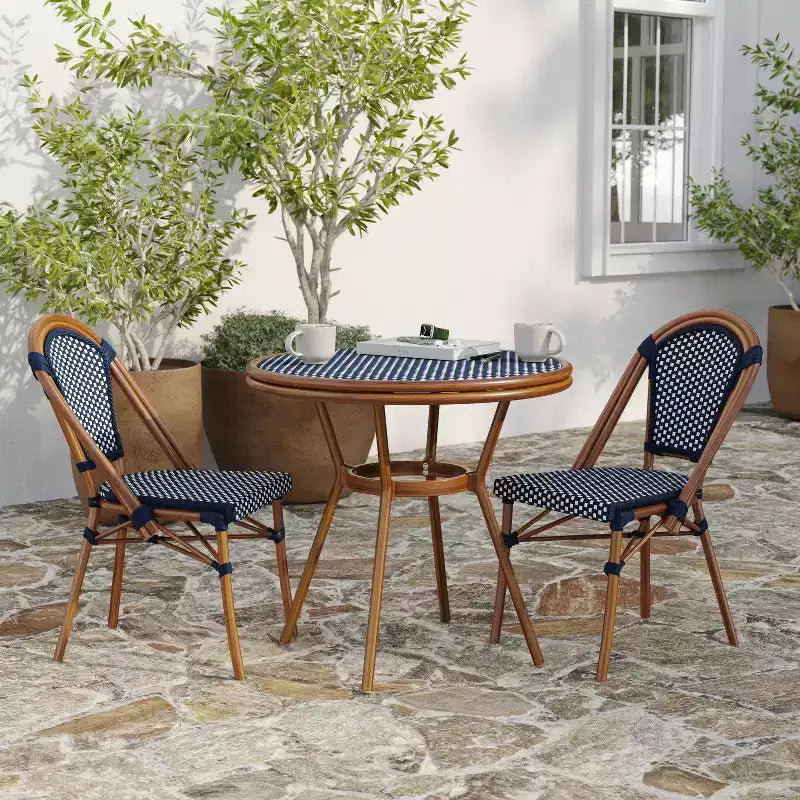 Table de style bistrot Celia de Merrick Lane avec plateau en verre trempé, rotin PE et cadre en métal finition bambou pour usage intérieur/extérieur.
