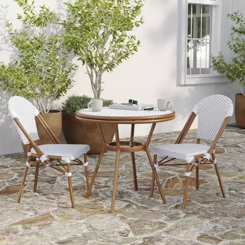 Table de style bistrot Celia de Merrick Lane avec plateau en verre trempé, rotin PE et cadre en métal finition bambou pour usage intérieur/extérieur.